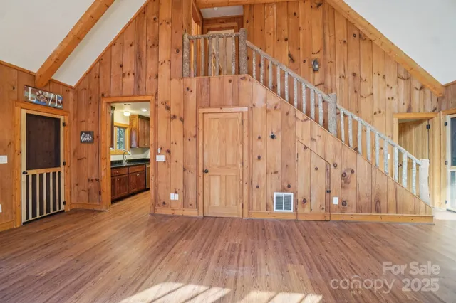 a view of a big room with wooden floor and windows