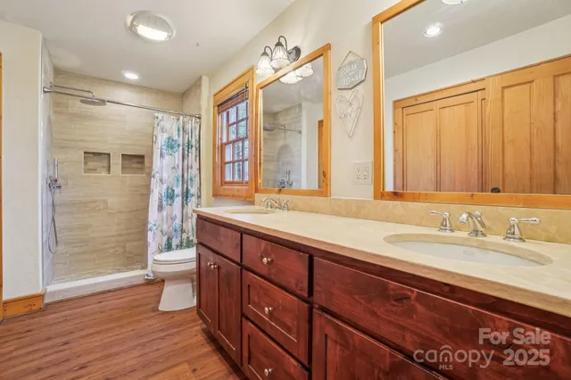 a spacious bathroom with a double vanity sink a large mirror and shower