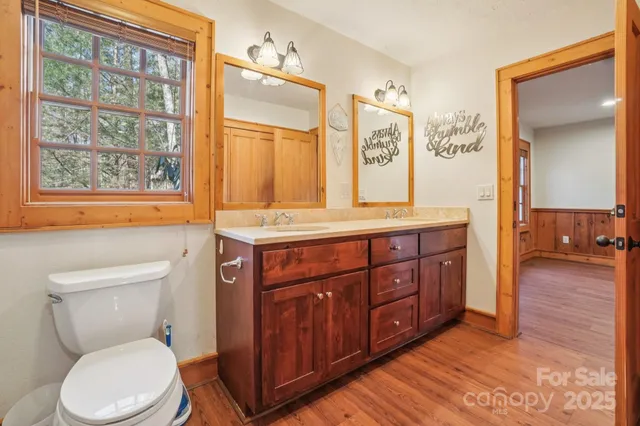 a bathroom with a granite countertop toilet sink and mirror