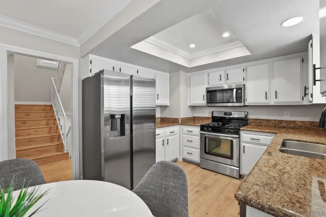 a kitchen with stainless steel appliances granite countertop a refrigerator sink and stove