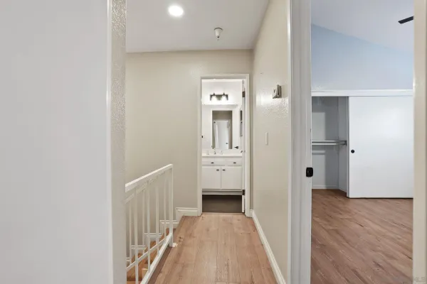a view of a hallway with wooden floor and closet
