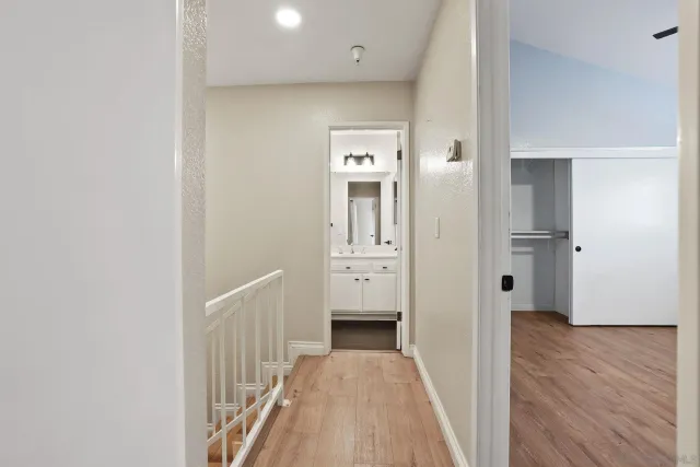a view of a hallway with wooden floor and closet