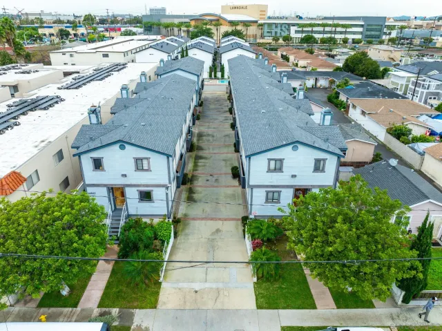 an aerial view of residential houses with outdoor space and a lake view