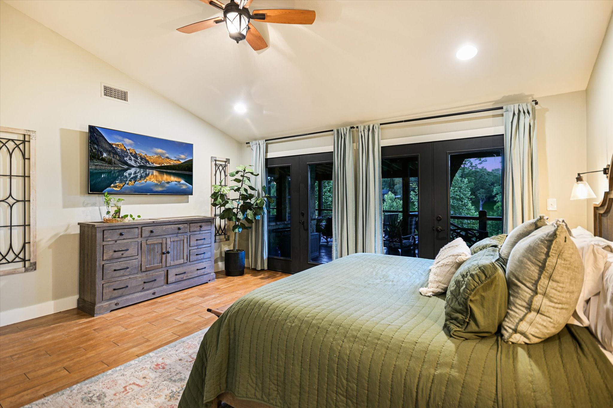 2411 Spoke Hollow Road Wimberley, TX 78676 - Photo 14 of 37 Step into a serene primary bedroom featuring vaulted ceilings and direct access to an outdoor retreat.