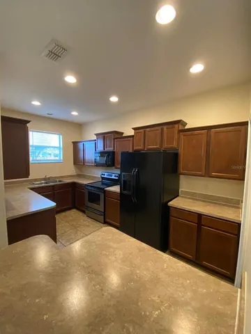 a kitchen with stainless steel appliances a stove a refrigerator and a sink