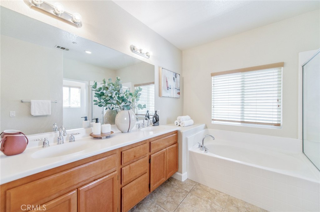 4947 Plumtree Court Riverside, CA 92504 - Photo 26 of 46 Master bath features dual vanities, a walk-in shower, a soaking tub, and two large walk-in closets