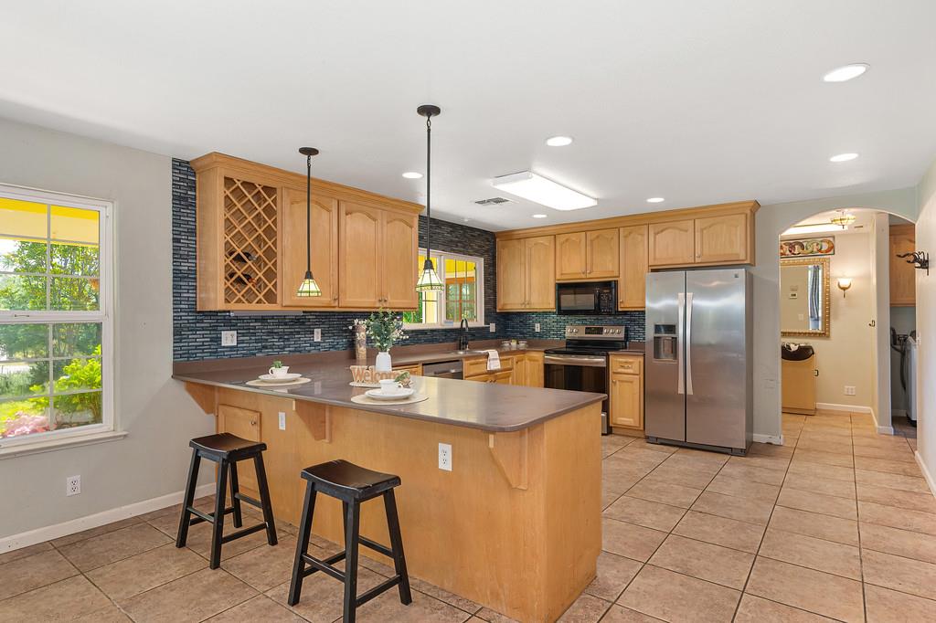 6181 Lambert Lane El Dorado, CA 95623 - Photo 26 of 80 a kitchen with stainless steel appliances granite countertop a sink a stove and a refrigerator