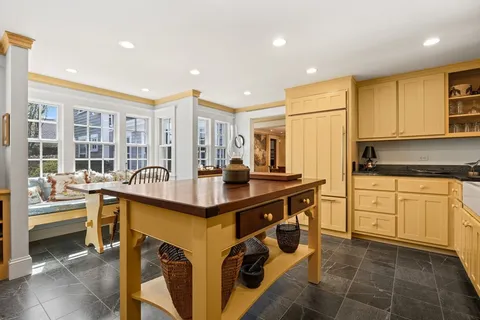 a kitchen with kitchen island granite countertop a sink and a stove top oven