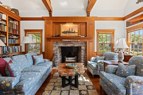 a living room with furniture fireplace and a large window
