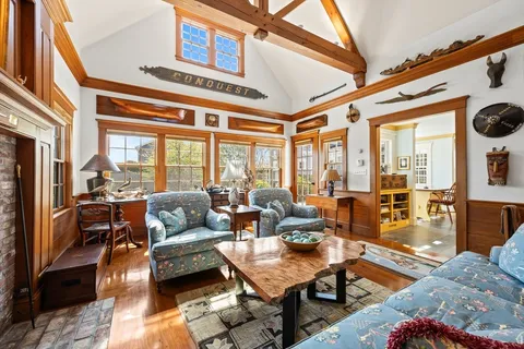 a living room with furniture a large window and a table