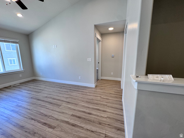 12339 Remy Road, Unit 422 Herriman, UT 84096 - Photo 14 of 36 Unfurnished living room with a ceiling fan, light wood-style flooring, recessed lighting, and lofted ceiling