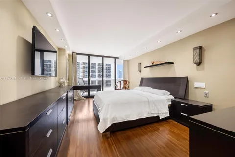 a bedroom with a bed and a large window