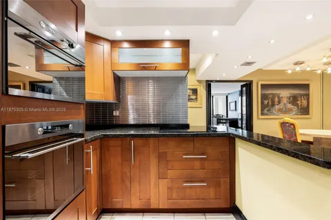 a kitchen with granite countertop a sink and wooden cabinets