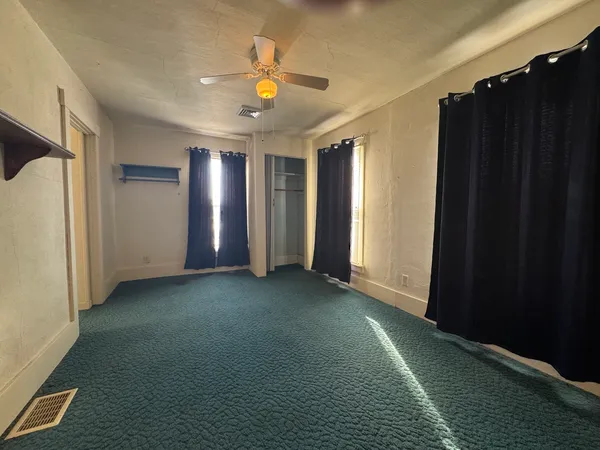 an empty room with windows and closet