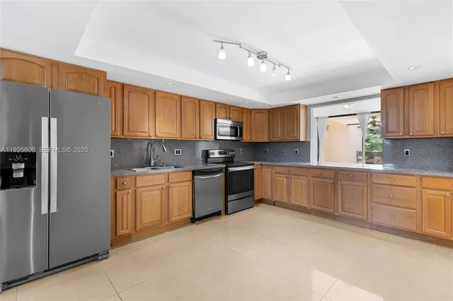 a kitchen with stainless steel appliances granite countertop a refrigerator sink and cabinets