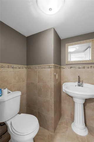 a white toilet sitting next to a bathroom sink