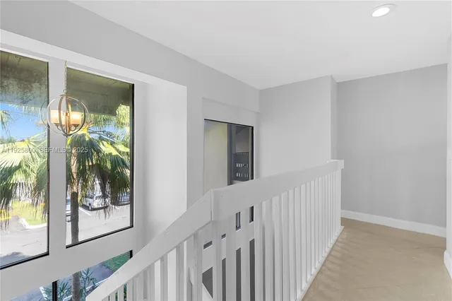a view of a hallway with wooden floor and windows