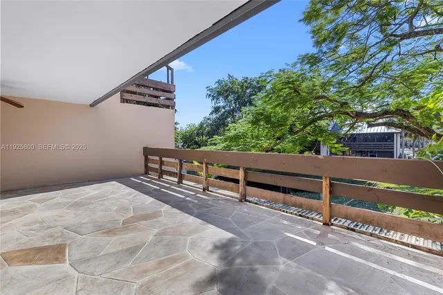 a view of balcony with wooden fence and trees
