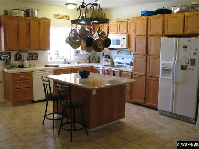 14355 Sitting Bull Circle Reno, NV 89521 - Photo 5 of 9 a kitchen with stainless steel appliances granite countertop a sink and a refrigerator