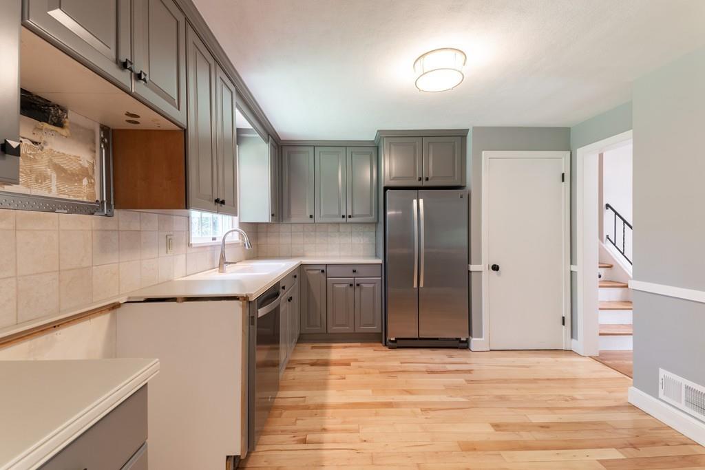 175 Powers Road Sudbury, MA 01776 - Photo 14 of 32 a kitchen with stainless steel appliances granite countertop a refrigerator and a sink