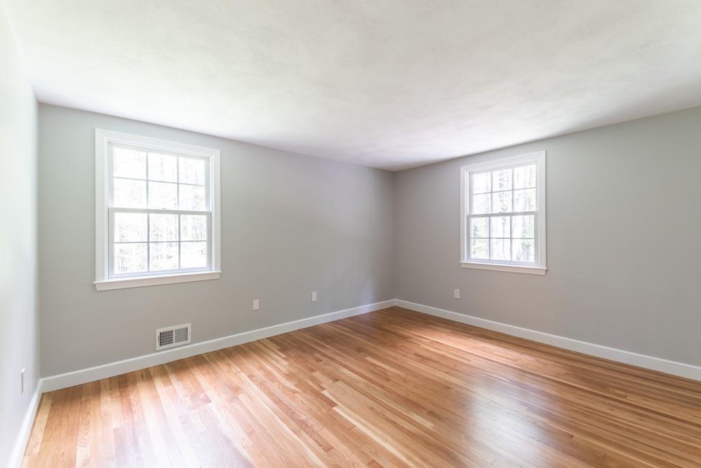 175 Powers Road Sudbury, MA 01776 - Photo 21 of 32 an empty room with wooden floor and windows