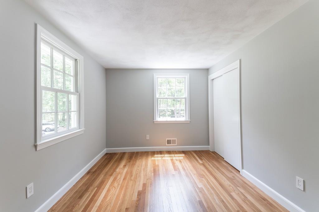 175 Powers Road Sudbury, MA 01776 - Photo 22 of 32 an empty room with wooden floor and windows