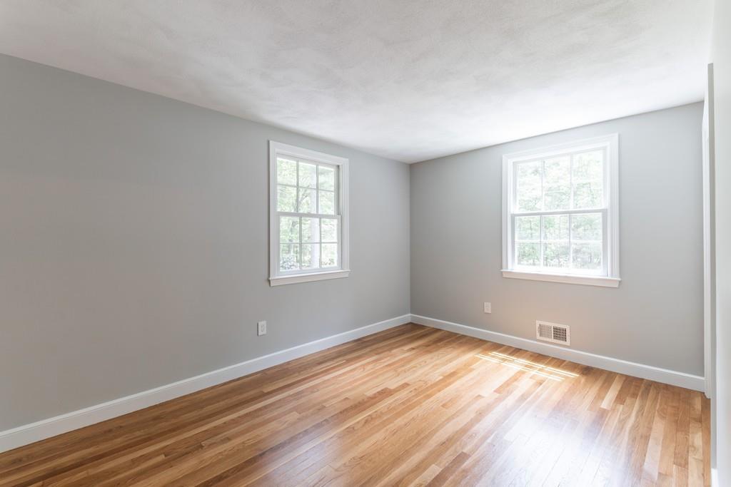 175 Powers Road Sudbury, MA 01776 - Photo 23 of 32 a view of an empty room with wooden floor and a window