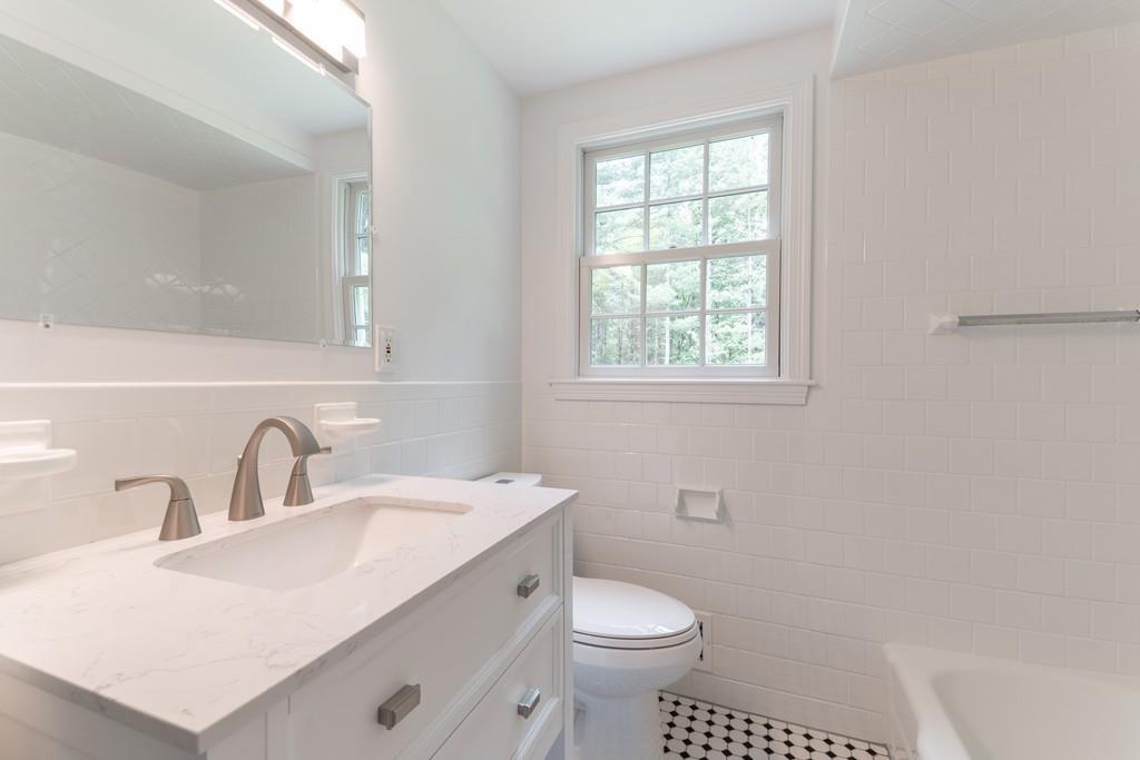 175 Powers Road Sudbury, MA 01776 - Photo 26 of 32 a bathroom with a sink toilet a mirror and a window