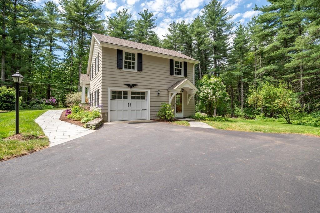 175 Powers Road Sudbury, MA 01776 - Photo 3 of 32 a front view of a house with a yard and garage