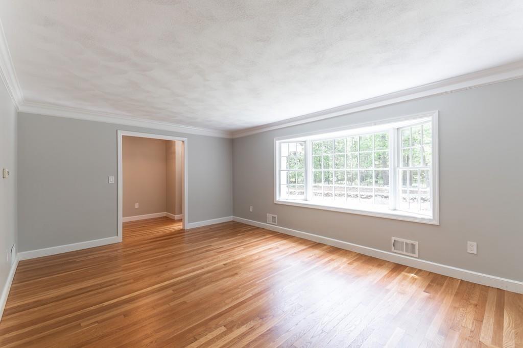175 Powers Road Sudbury, MA 01776 - Photo 7 of 32 a view of an empty room with wooden floor and a window