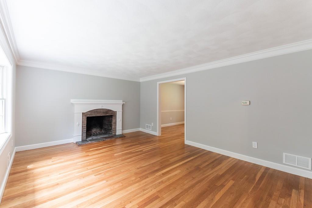 175 Powers Road Sudbury, MA 01776 - Photo 8 of 32 a view of empty room with wooden floor and fireplace