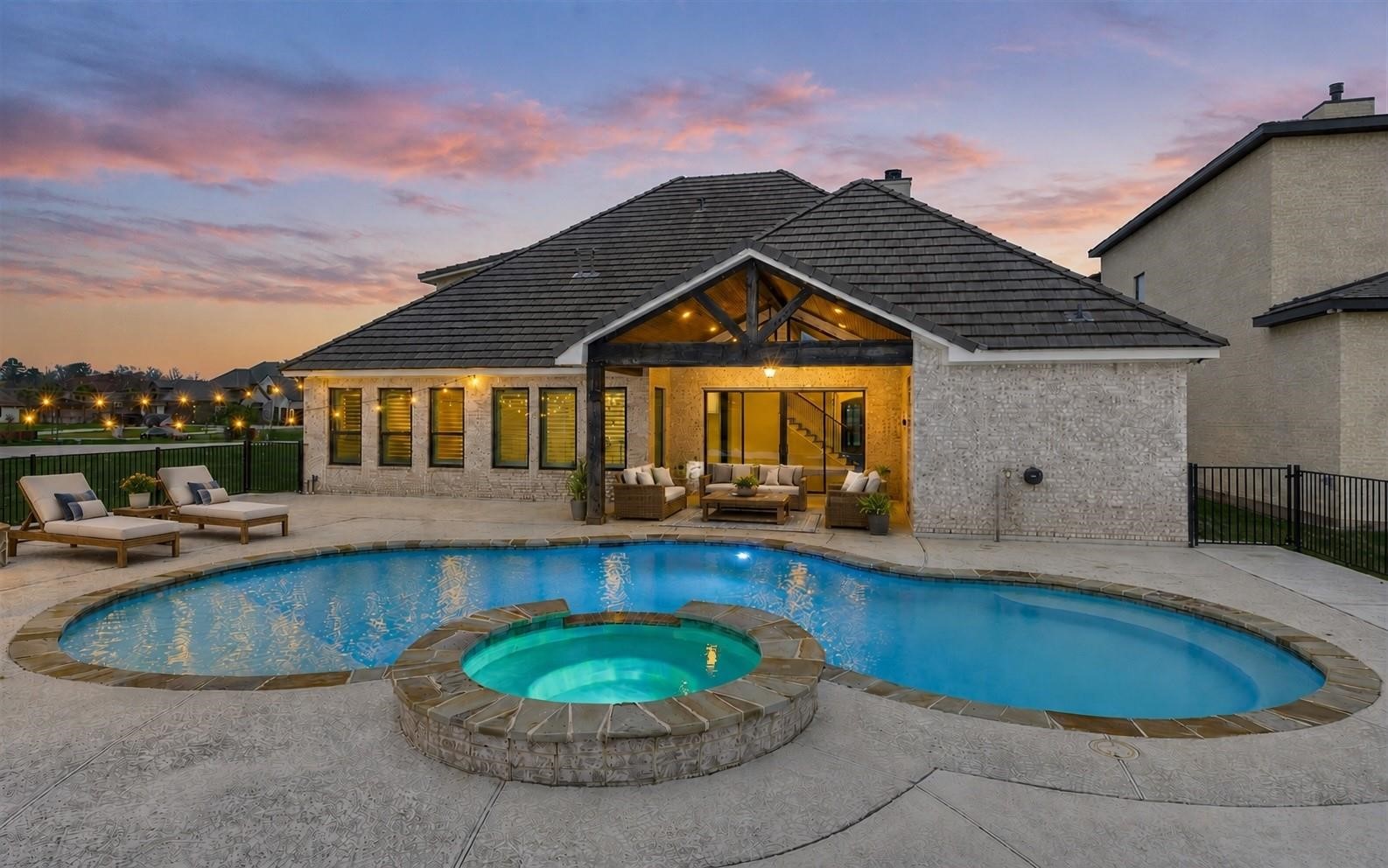 11618 Renaissance Drive Montgomery, TX 77356 - Photo 3 of 47 The rear elevation shows the sparkling chlorine pool with a seating bench at the perimeter and changeable lighting for added ambiance. Virtually staged with patio furniture.