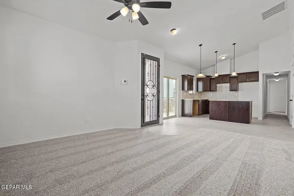 a view of a kitchen with furniture and a ceiling fan