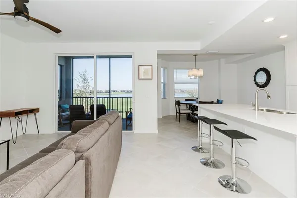 a living room with furniture a large window and gym equipment