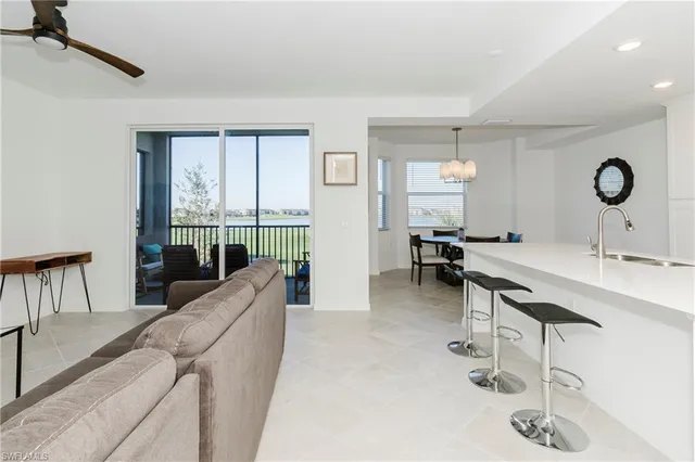 a living room with furniture a large window and gym equipment