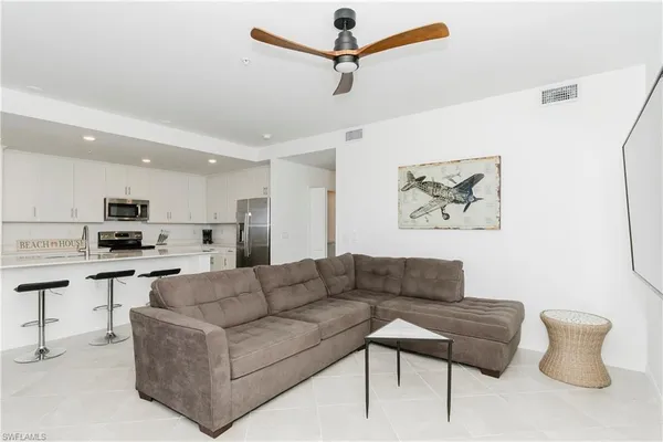 a living room with furniture kitchen view and a potted plant