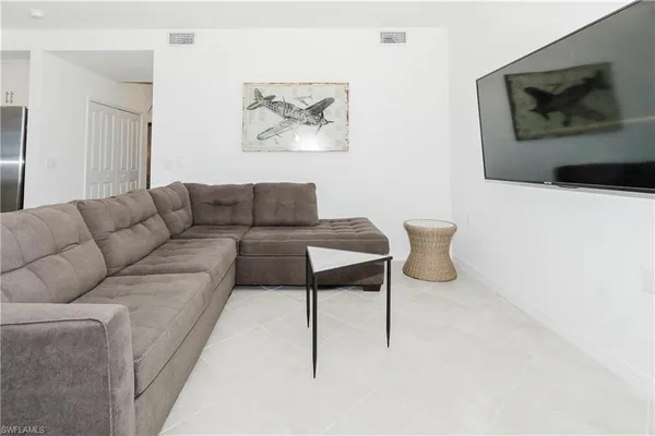 a living room with furniture and a painting on the wall