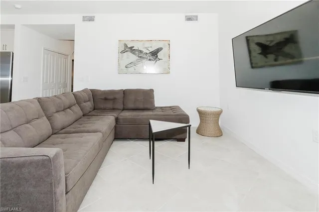 a living room with furniture and a painting on the wall