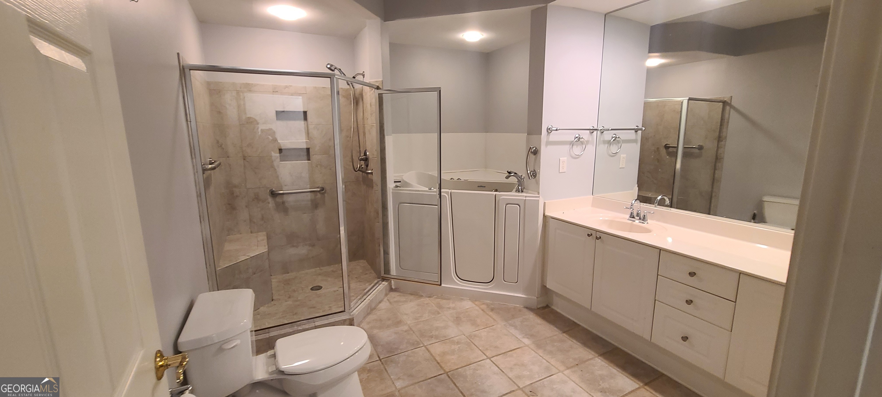 3047 Lenox Road Northeast, Unit 2107 Atlanta, GA 30324 - Photo 8 of 27 a bathroom with a shower sink mirror and toilet