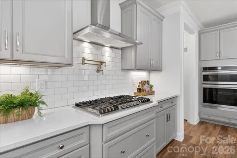 a kitchen with stainless steel appliances white cabinets and a stove