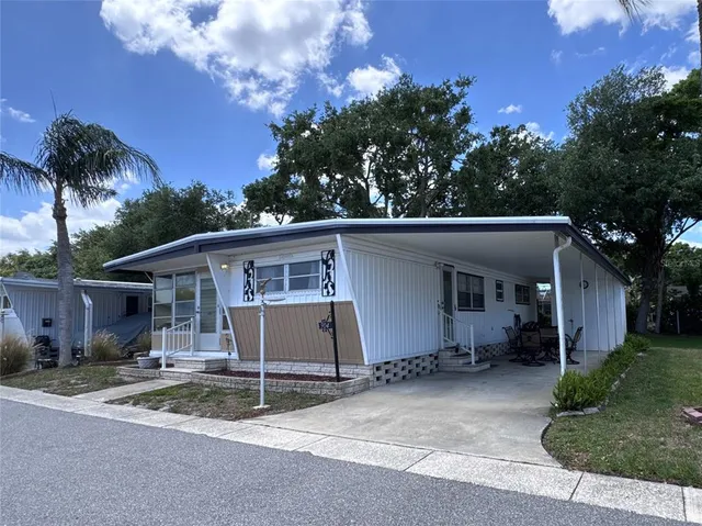 front view of a house with a yard and potted plants