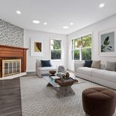 a living room with furniture floor to ceiling window hardwood floor and a flat screen tv