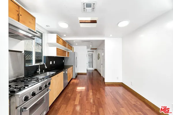 a kitchen with stainless steel appliances a stove a sink and a refrigerator