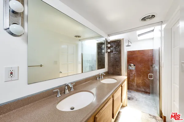 a bathroom with a granite countertop sink and a mirror