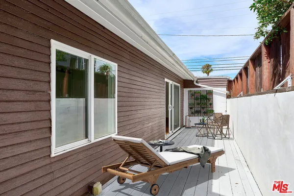 a patio with wooden table and chairs