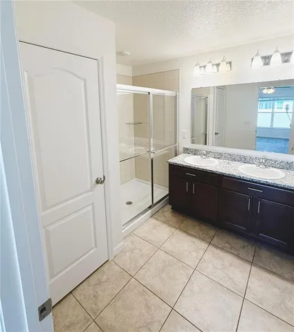 a spacious bathroom with a granite countertop sink mirror and bathtub