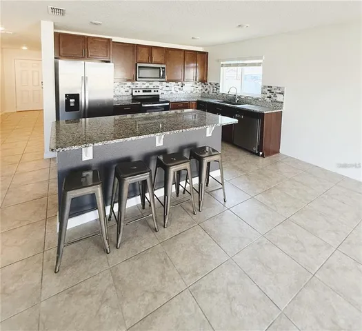 a large kitchen with a table and chairs