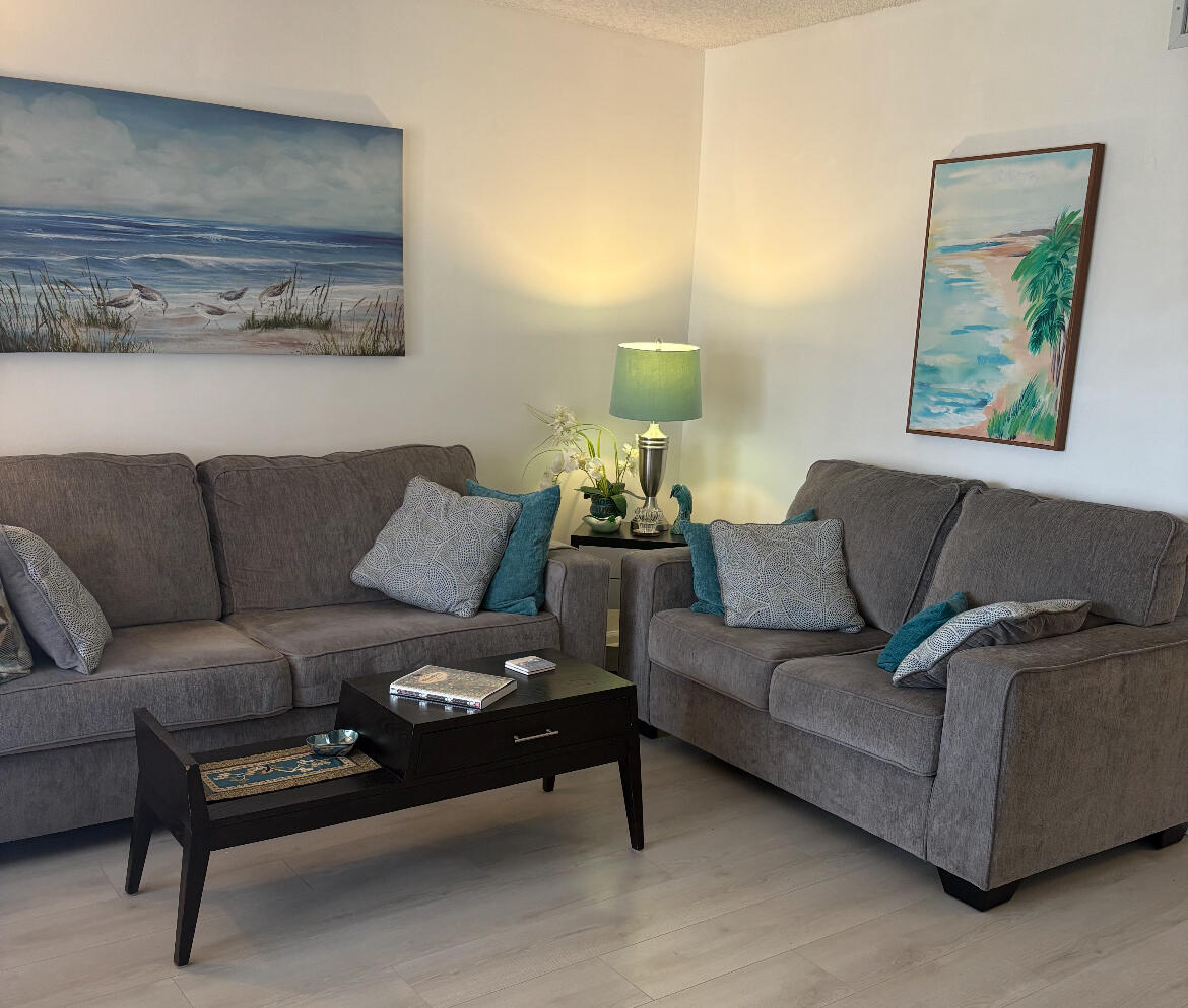 540 Southwest South River Drive, Unit 204 Stuart, FL 34997 - Photo 5 of 15 a living room with furniture and a painting