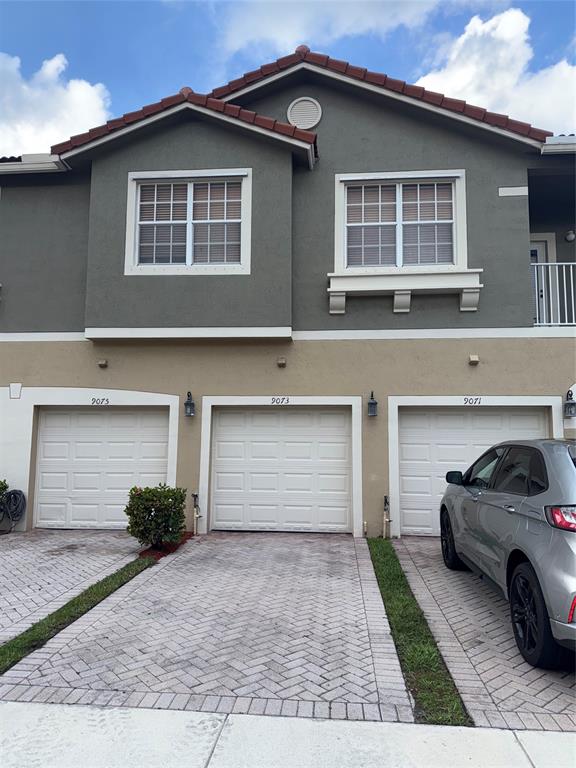 9073 Plymouth Place Tamarac, FL 33321 - Photo 1 of 16 a front view of a house with a yard and garage