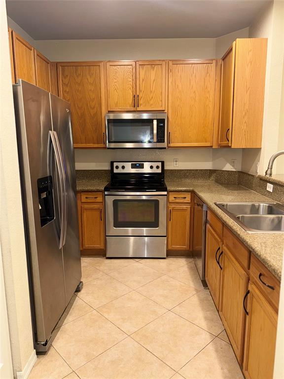 9073 Plymouth Place Tamarac, FL 33321 - Photo 11 of 16 a kitchen with stainless steel appliances granite countertop a stove a sink and a microwave